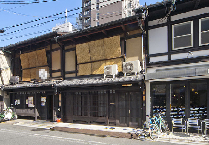京都市中心部にある京町家の改装工事です（中央の町家）。外観上の変更は、玄関扉の新調と大屋根の瓦を耐震性重視でガルバリウムに変更した程度です。